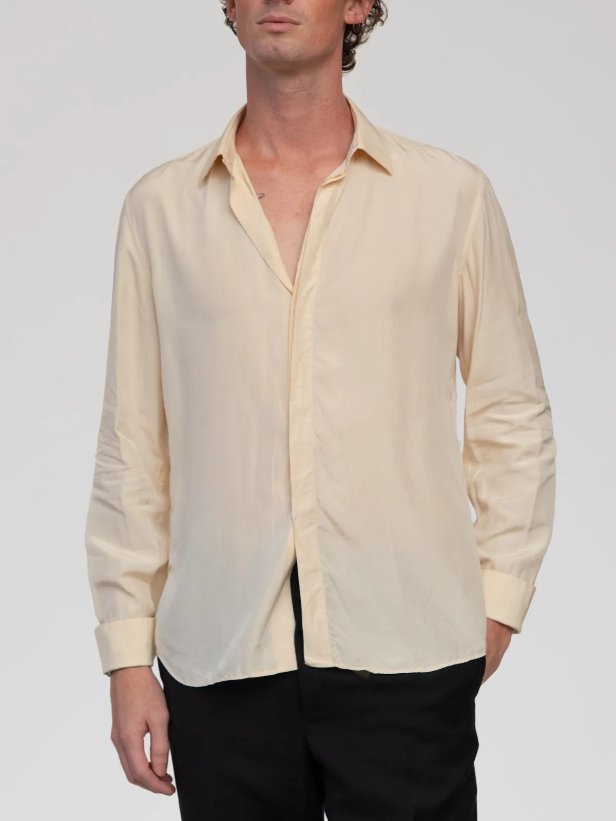 Vintage Valentino Chemises pale cream silk long-sleeve dress shirt featuring a classic point collar, a concealed button-front placket, single-button barrel cuffs, and a subtly curved hemline. Made in Italy. - Image 1