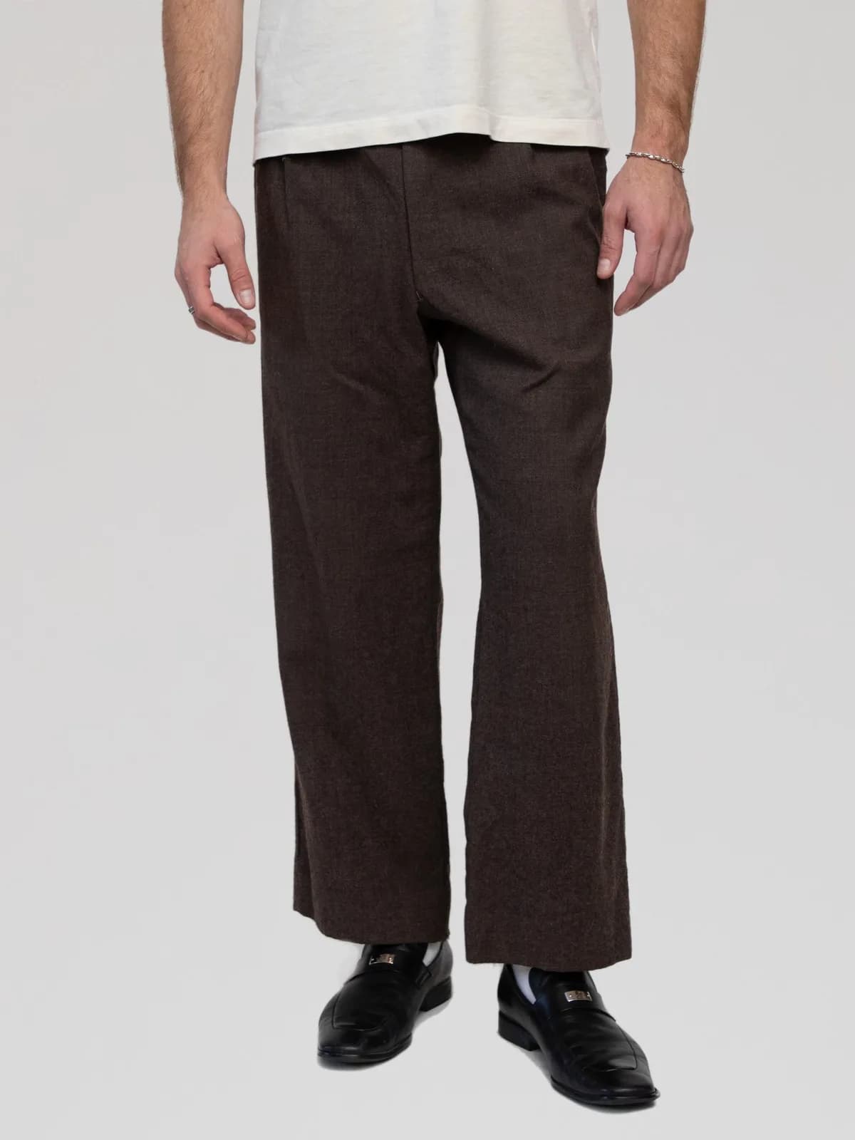 Christian Dior Monsieur dark brown wool trousers cut in a relaxed, wide-leg silhouette, featuring side slip pockets, a rear welt pocket, and an inner waistband lined with branded "Christian Dior MONSIEUR" tape trim. - Image 1