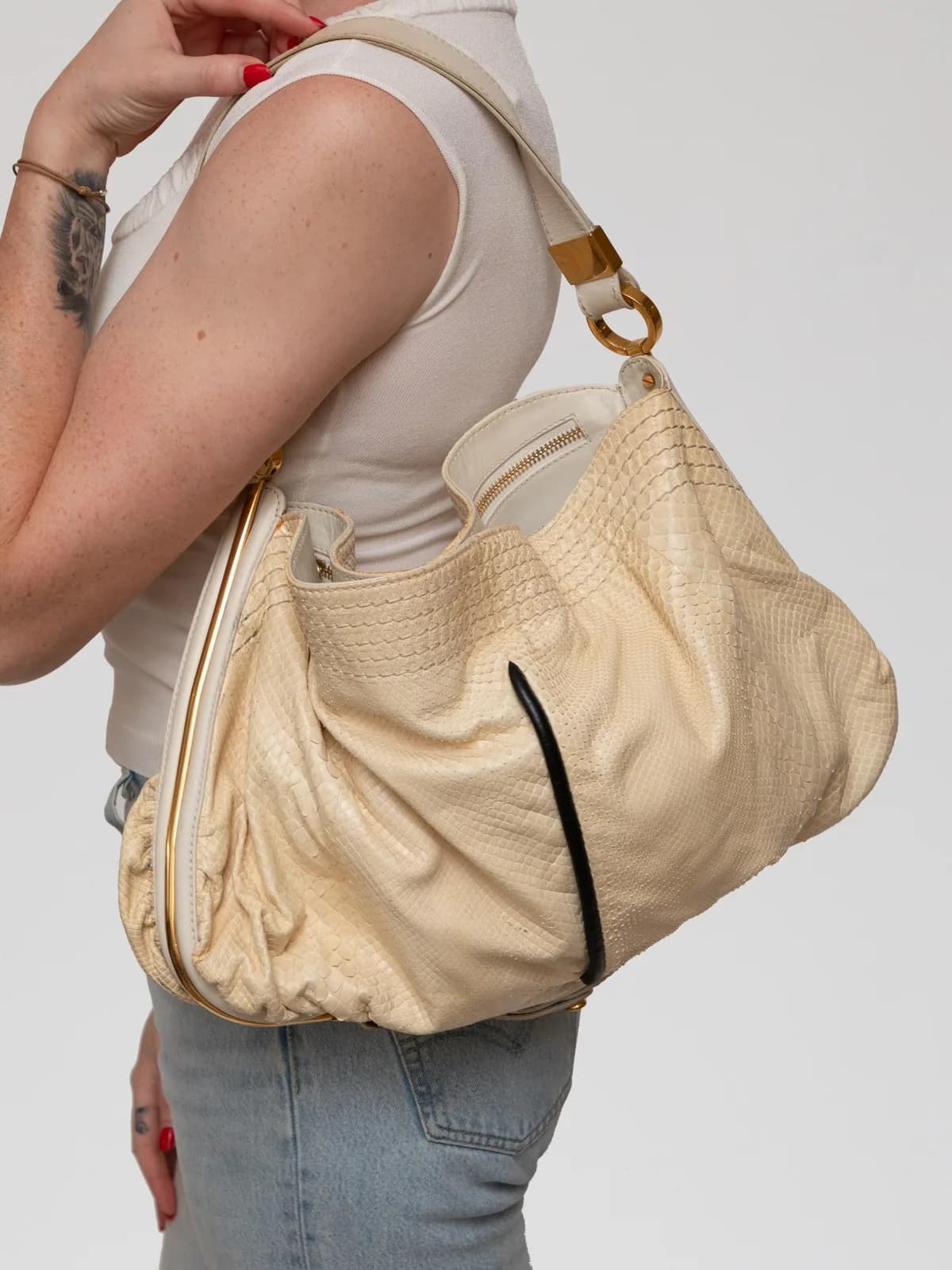 Exquisitely crafted in cream-hued python snakeskin, this slouchy Jimmy Choo shoulder bag features a relaxed, gathered silhouette complemented by polished gold-tone hardware and a plush suede interior lining. - Image 1