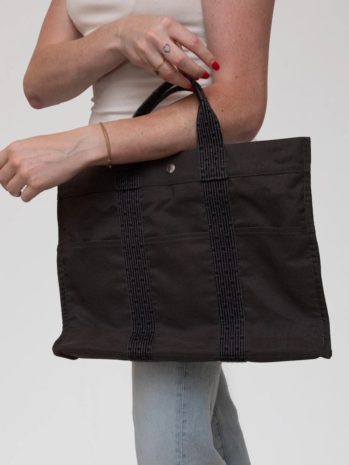 Woven from durable canvas with signature Hermès webbing handles, this classic Fourre-Tout MM tote marries Parisian utilitarian style with understated luxury for effortless everyday function. - Image 1