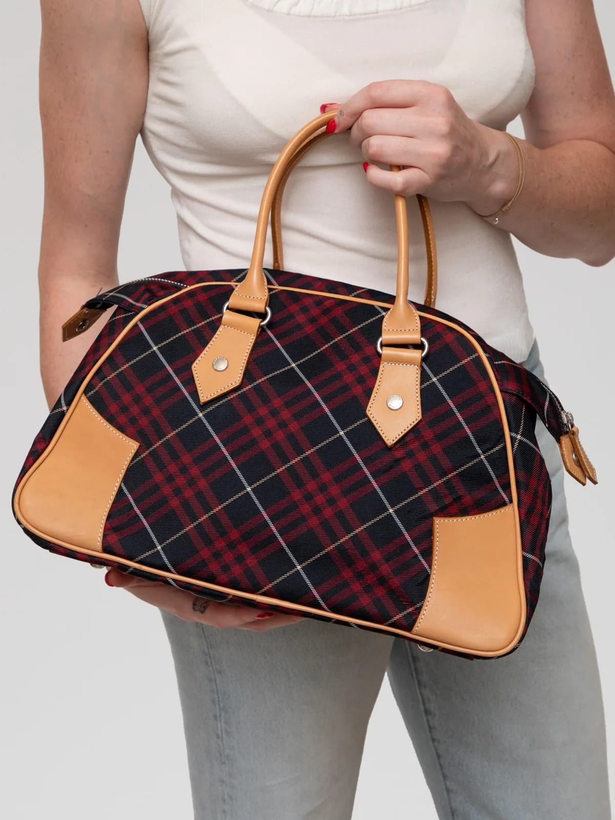 Showcasing a bold navy and red plaid canvas trimmed with warm tan leather and silver-tone hardware, this vintage Burberry Blue Label handbag combines classic British pattern heritage with a preppy, structural design. - Image 1