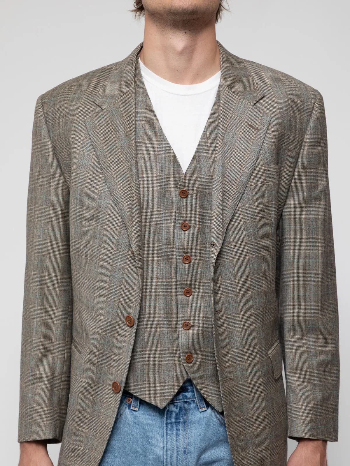 Mid 00's blazer and waistcoat set in brown prince of wales check. The blazer features a notch lapel, 3 button design, flap pockets and double vent. The waistcoat features 6 button design, slit pockets and adjuster on the back. The cloth is by Botto Giuseppe & Figli of Biella Italy - Image 1