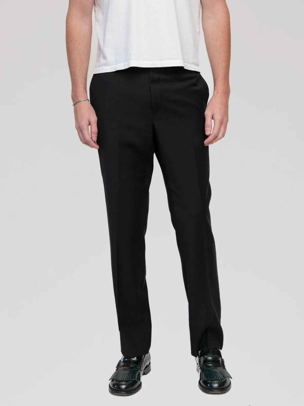 Hedi Slimane Era Dior Homme black tailored dress trousers featuring a slim, straight-leg silhouette with sharp pressed leg creases, side slip pockets, rear welt pockets, a concealed zip fly, and a tab closure waistband. Crafted in Italy from 100% Super 100s wool with a Bemberg lining. - Image 1
