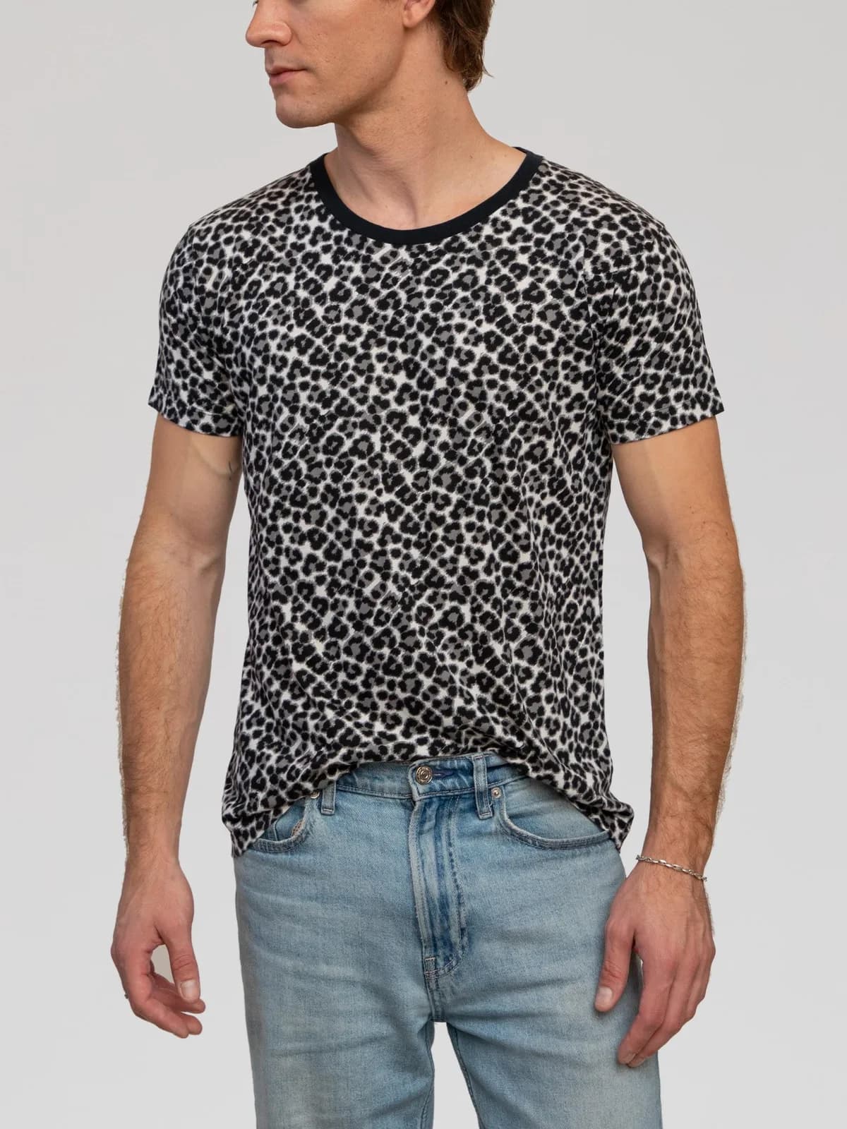 Hedi Slimane Era Saint Laurent Paris short-sleeve t-shirt featuring an all-over grey and black snow leopard spot print. Crafted from a soft, lightweight jersey fabric, it is styled with a slim fit, short sleeves, a straight hemline, and a contrasting black ribbed crewneck collar. Made in Italy. - Image 1