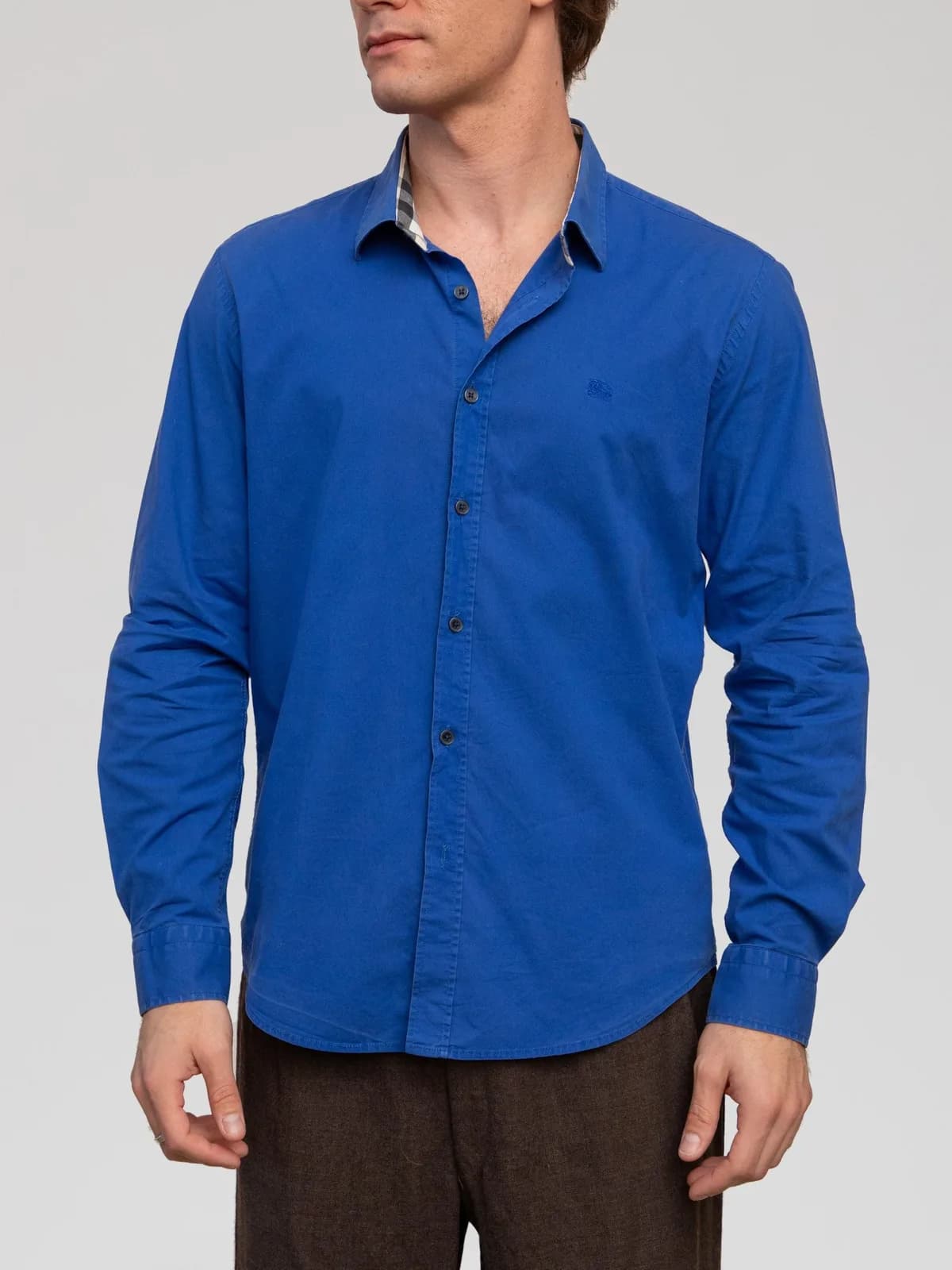 Burberry Brit cobalt blue long-sleeve cotton shirt featuring a point collar lined with House check trim, tonal embroidered Equestrian Knight logo at the left chest, a buttoned front placket, barrel cuffs, and a slightly curved hem. - Image 1